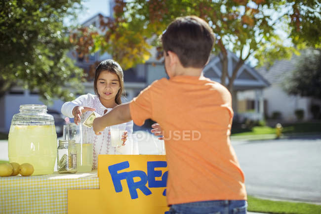 Menino compra limonada no quiosque de limonada — Fotografia de Stock