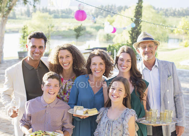 Щаслива сучасна сім'я посміхається разом на відкритому повітрі — стокове фото