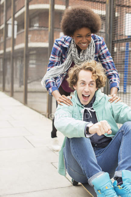 Couple playing on skateboard on city street — Stock Photo