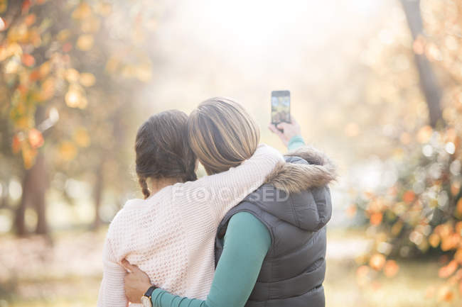 Affectionate mother and daughter taking selfie outdoors — Stock Photo
