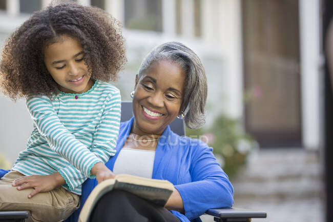 Nonna e nipote lettura libro sul patio — Foto stock