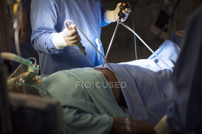 Chirurgo in possesso di strumenti medici ed eseguire chirurgia laparoscopica in sala operatoria — Foto stock