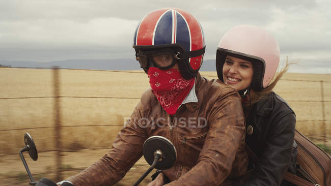 Jovem casal equitação motocicleta no campo rural — Fotografia de Stock