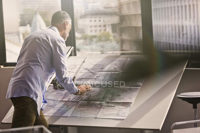 Architect reviewing blueprints in office — Stock Photo
