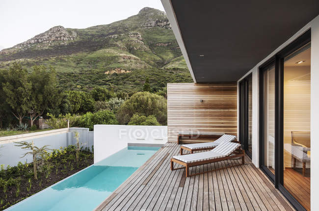 Moderno, casa di lusso vetrina patio esterno con piscina sul giro con vista sulle montagne — Foto stock