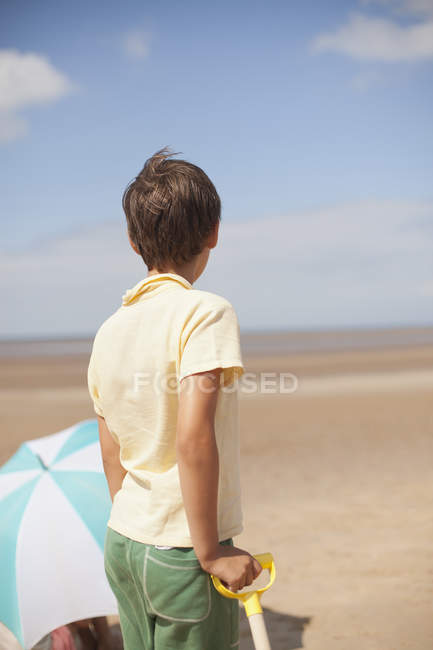 Надійний хлопець дивиться далеко на сонячний літній пляж — стокове фото