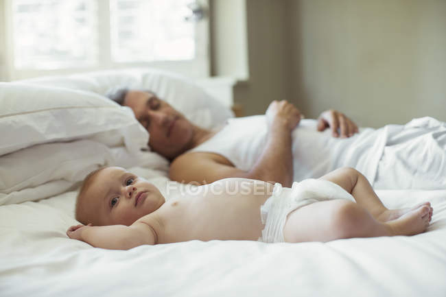 Батько і дитина лежать на ліжку — стокове фото