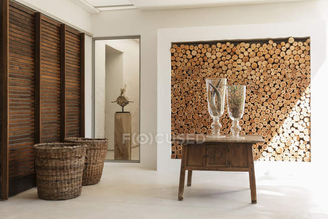 Wood logs in wall and table in modern foyer — Stock Photo