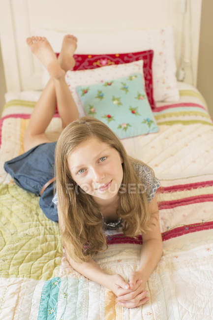 Menina deitada na cama dentro de casa — Fotografia de Stock