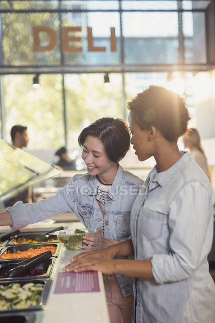 Giovani amiche al buffet di insalate al supermercato — Foto stock