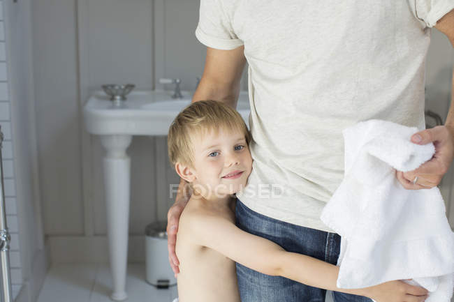 Junge umarmt Vater im Badezimmer — Stockfoto