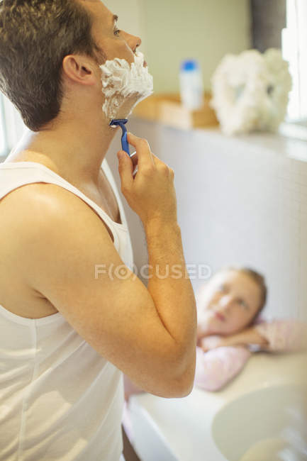 Mädchen beobachtet Vater bei Rasur im Badezimmer — Stockfoto