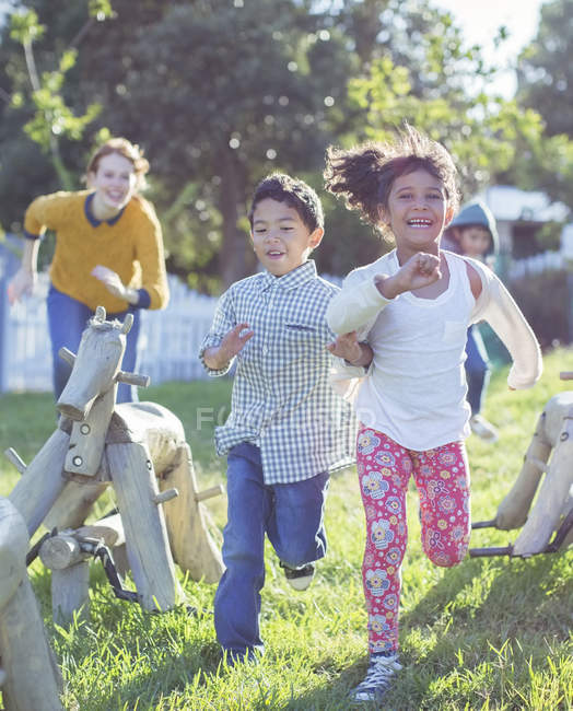 Crianças que correm no parque infantil durante o dia — Fotografia de Stock