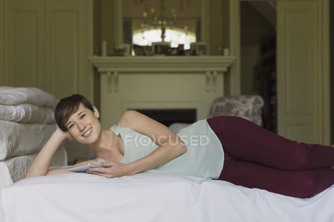 Junge Frau liegt auf Bett im Zimmer — Stockfoto