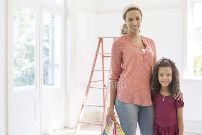 Mutter und Tochter lächeln im Wohnzimmer — Stockfoto