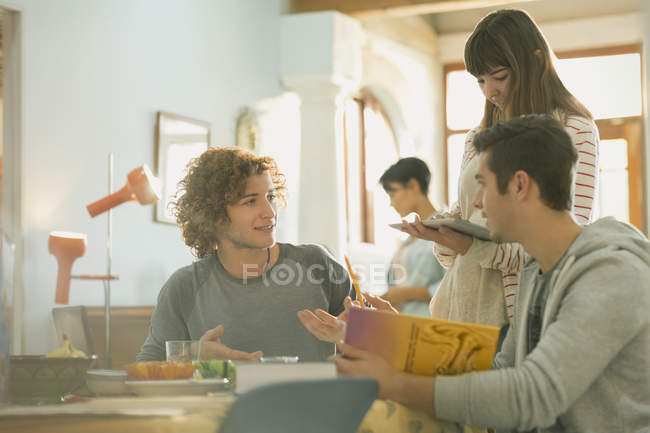 Young friends college students studying with book and digital tablet at table — Stock Photo