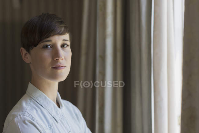 Portrait confident brunette woman at window — Stock Photo