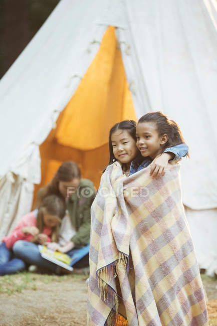 Дівчата загорнуті в ковдру на місці кемпінгу — стокове фото