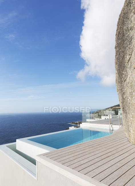 Modern swimming pool overlooking ocean — Stock Photo