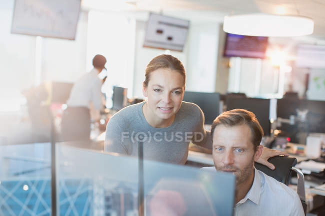 Businessman and businesswoman working at computer in office — Stock Photo