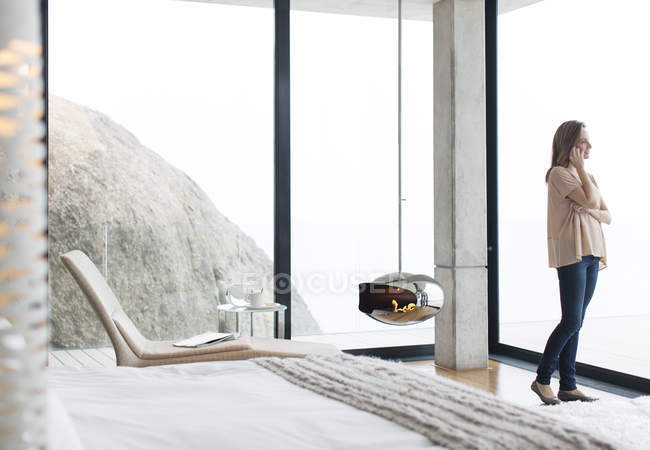 Frau telefoniert in modernem Schlafzimmer — Stockfoto