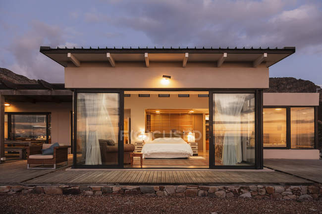 Иллюминированная домашняя витрина спальни с открытыми дверями патио — стоковое фото