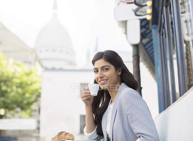 Mujer bebiendo espresso en la cafetería de la acera cerca de Sacre Coeur Basilica, París, Francia - foto de stock