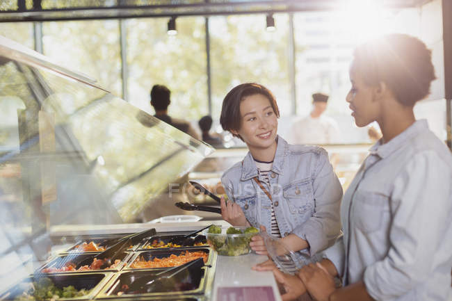 Young lesbian couple at salad bar in market — Stock Photo
