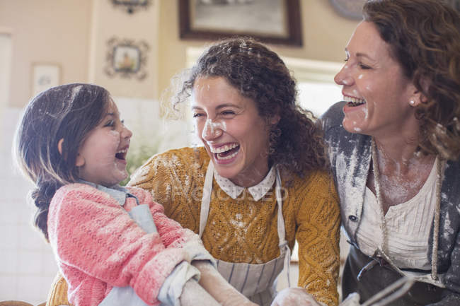 Tres generaciones de mujeres jugando en la cocina - foto de stock