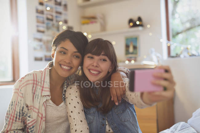 Enthusiastic young women friends taking selfie with camera phone — Stock Photo