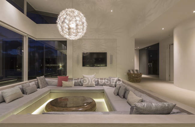 Iluminada moderna casa de luxo vitrine interior sala de estar com lustre — Fotografia de Stock
