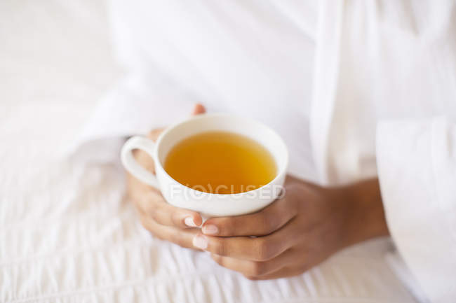Крупним планом жінка тримає чашку чаю — стокове фото
