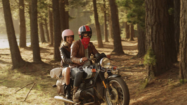 Jovem casal andar de moto na floresta — Fotografia de Stock