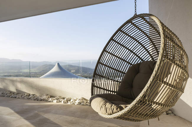 Hanging rattan seat on modern luxury patio — Stock Photo