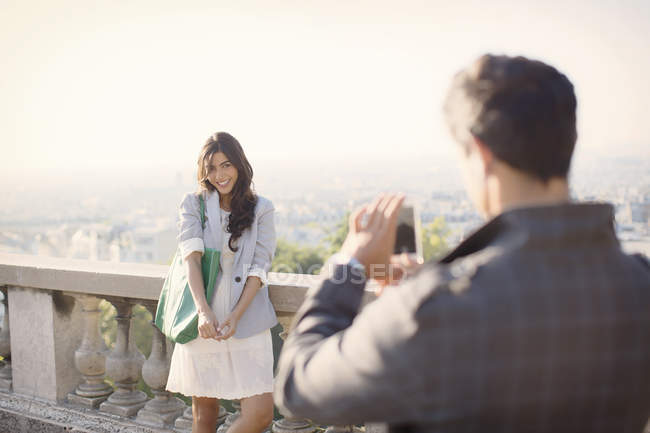 Homem fotografando namorada com Paris no fundo — Fotografia de Stock