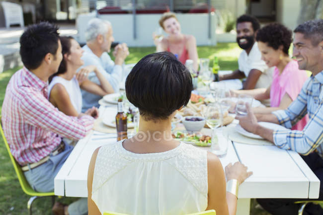 Друзья разговаривают за столом на улице — стоковое фото
