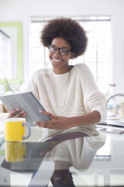 Женщина за столом дома с цифровым планшетом — стоковое фото