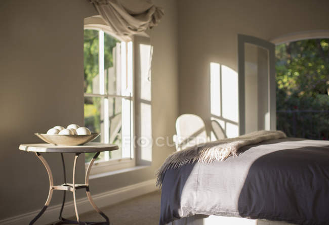 Солнечная роскошная спальня против окон — стоковое фото
