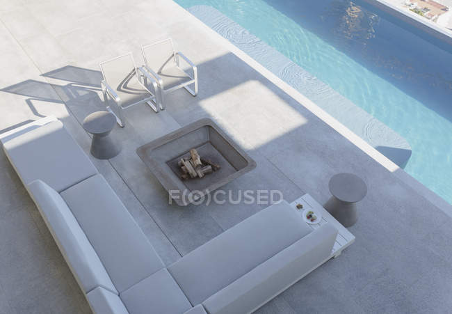 Vista elevada moderno, lujoso patio exterior escaparate casa con sofá, chimenea y piscina regazo - foto de stock