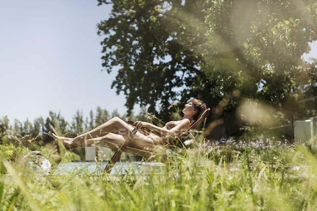 Woman relaxing in lounge chair outdoors — Stock Photo