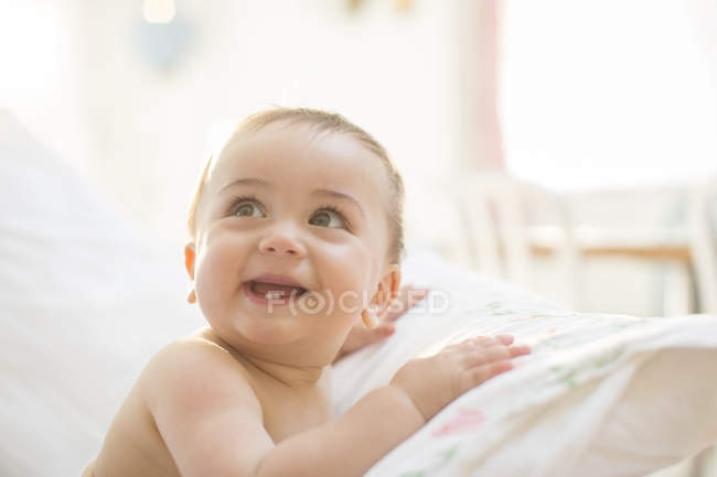 Bébé garçon souriant au lit — Photo de stock