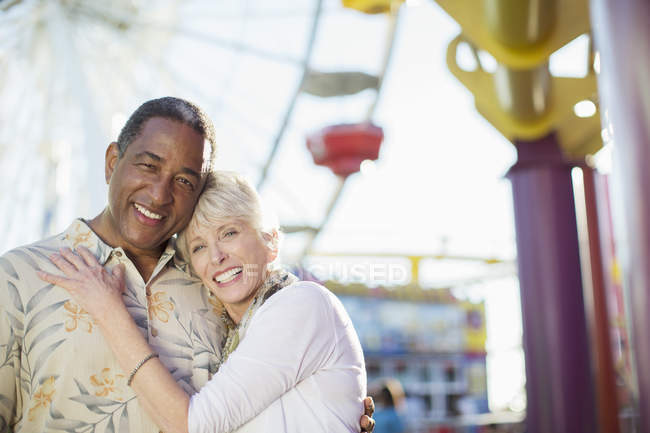 Портрет улыбающейся пожилой пары в парке развлечений — стоковое фото