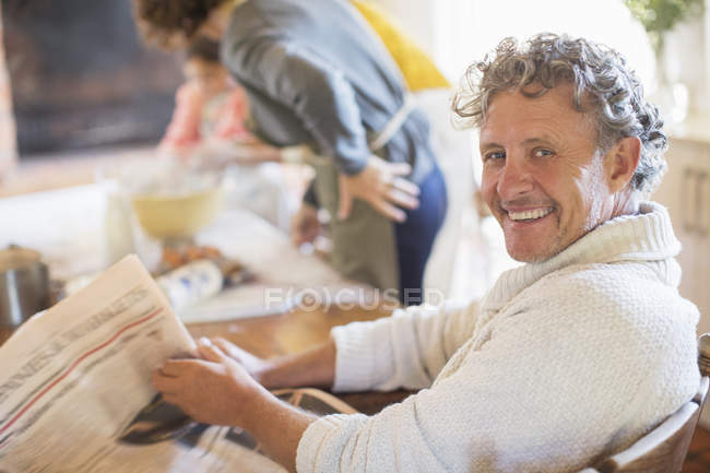 Uomo più anziano che legge il giornale in cucina — Foto stock