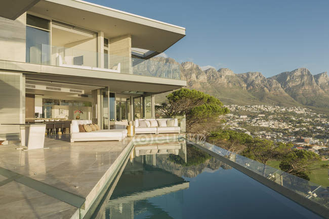 Солнечный современный роскошный дом с бассейном и видом на горы — стоковое фото