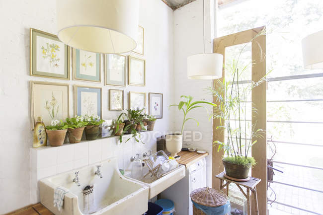 Wandbehänge und Lampen über rustikaler Küchenspüle — Stockfoto