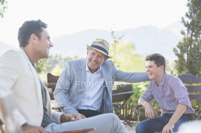 Three generations of men relaxing outdoors — Stock Photo