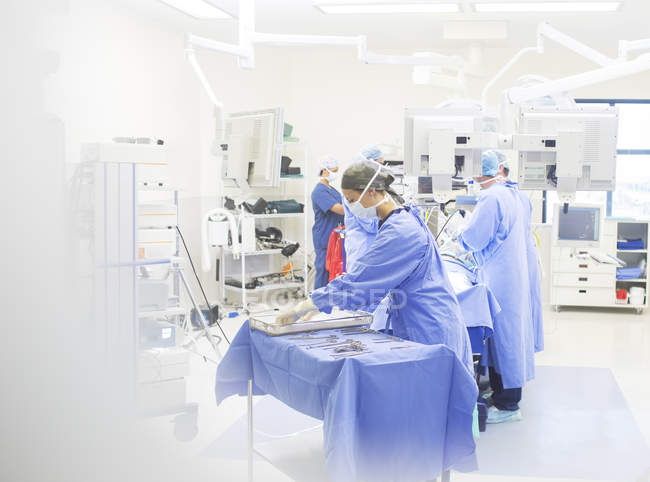 Equipo de cirujanos realizando cirugía en quirófano - foto de stock