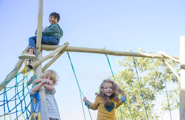 Niños jugando en la estructura del juego - foto de stock