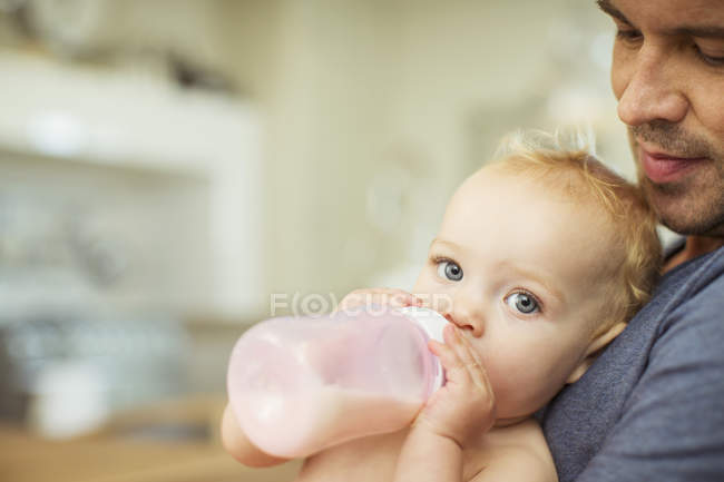 Padre alimentación bebé en cocina - foto de stock