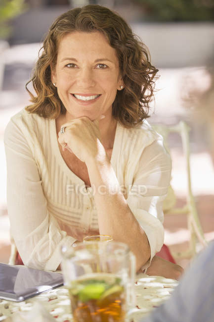 Glücklich kaukasische ältere Frau sitzt am Tisch im Freien — Stockfoto